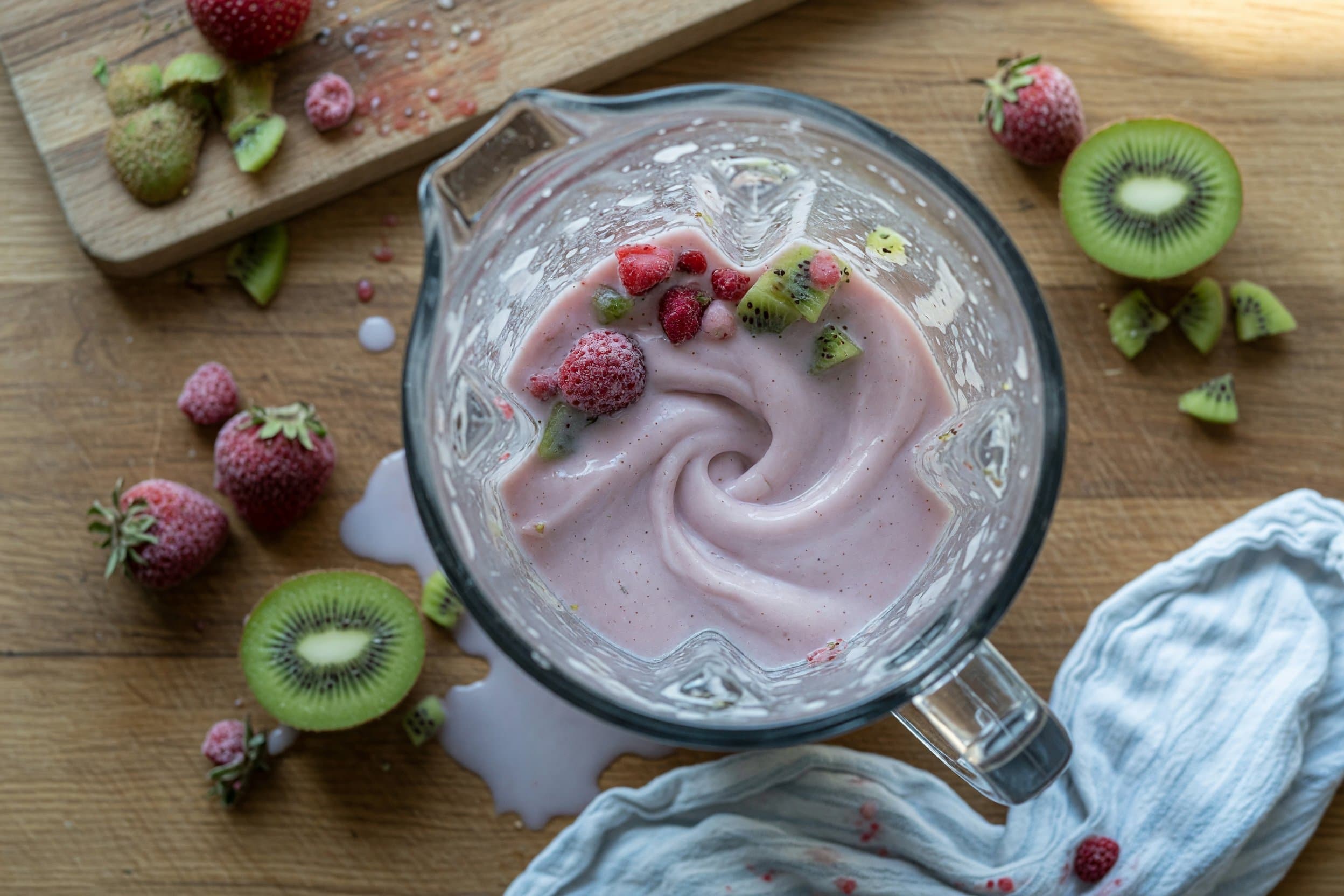 Stirring frozen strawberries, kiwis, and milk while preparing The BEST Strawberry Kiwi Dole Whip