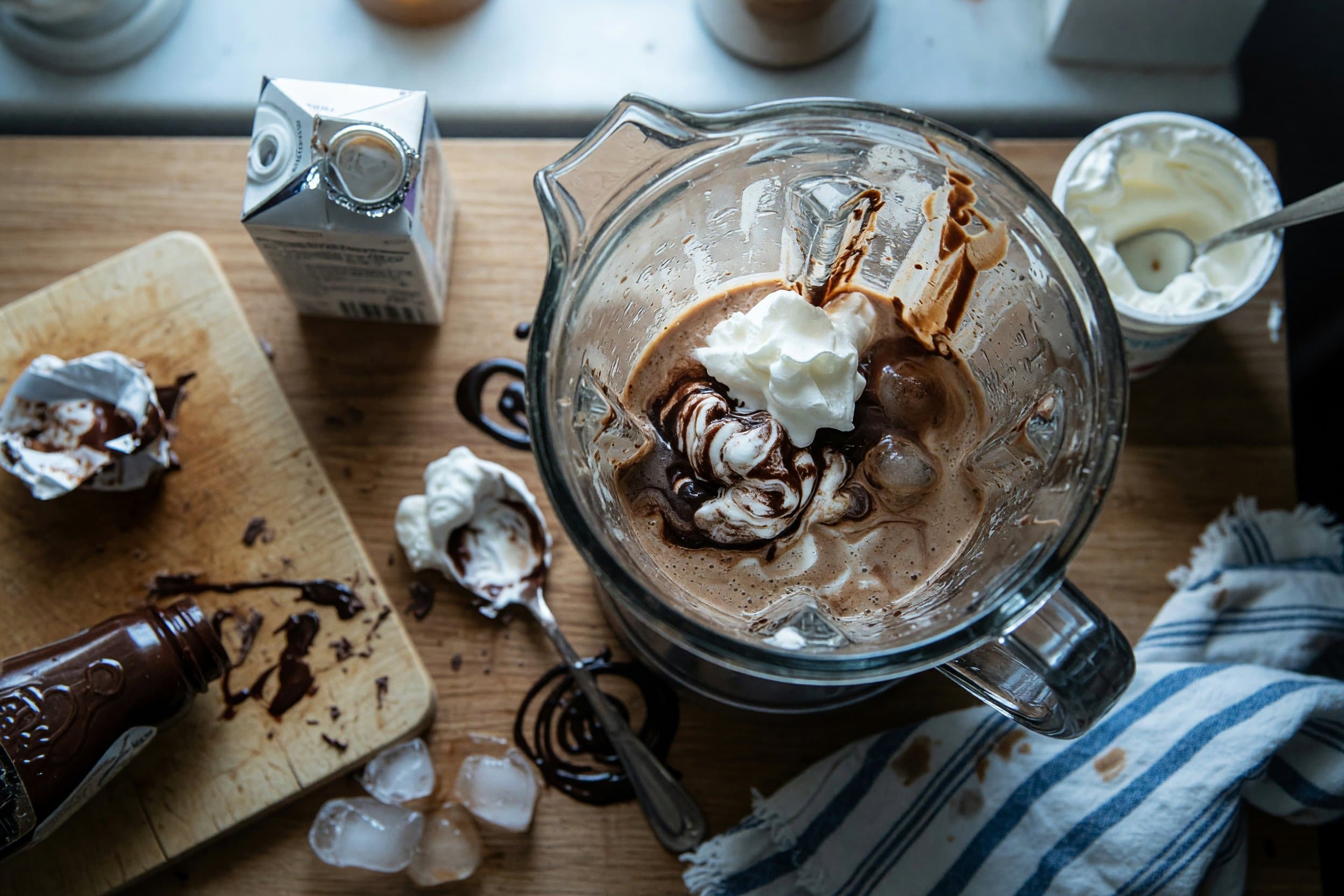 Stirring coffee, whipped topping, chocolate syrup, creamer, and ice while preparing Frozen Coffee Recipe