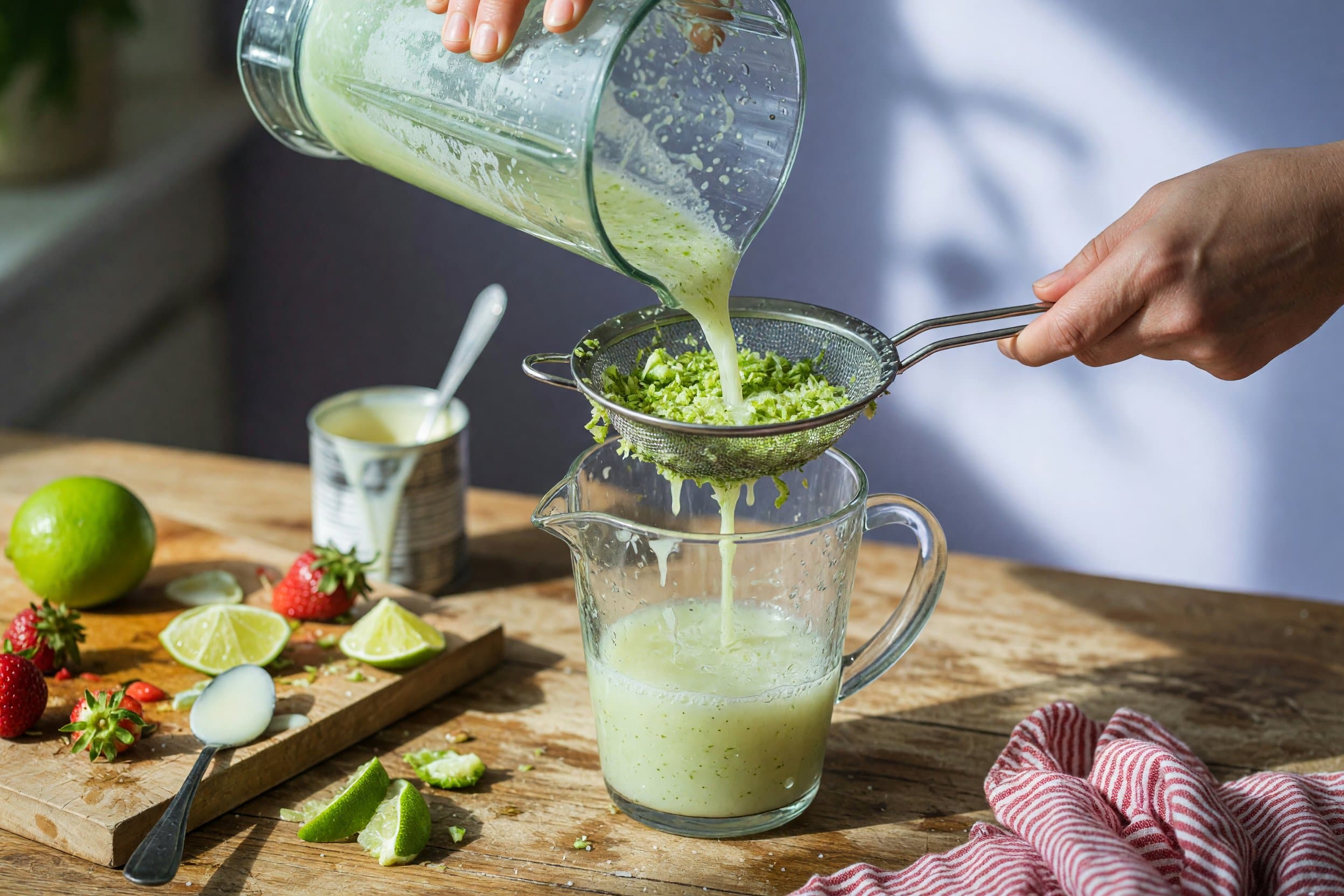 Pouring lime water while preparing Brazilian Strawberry Limeade