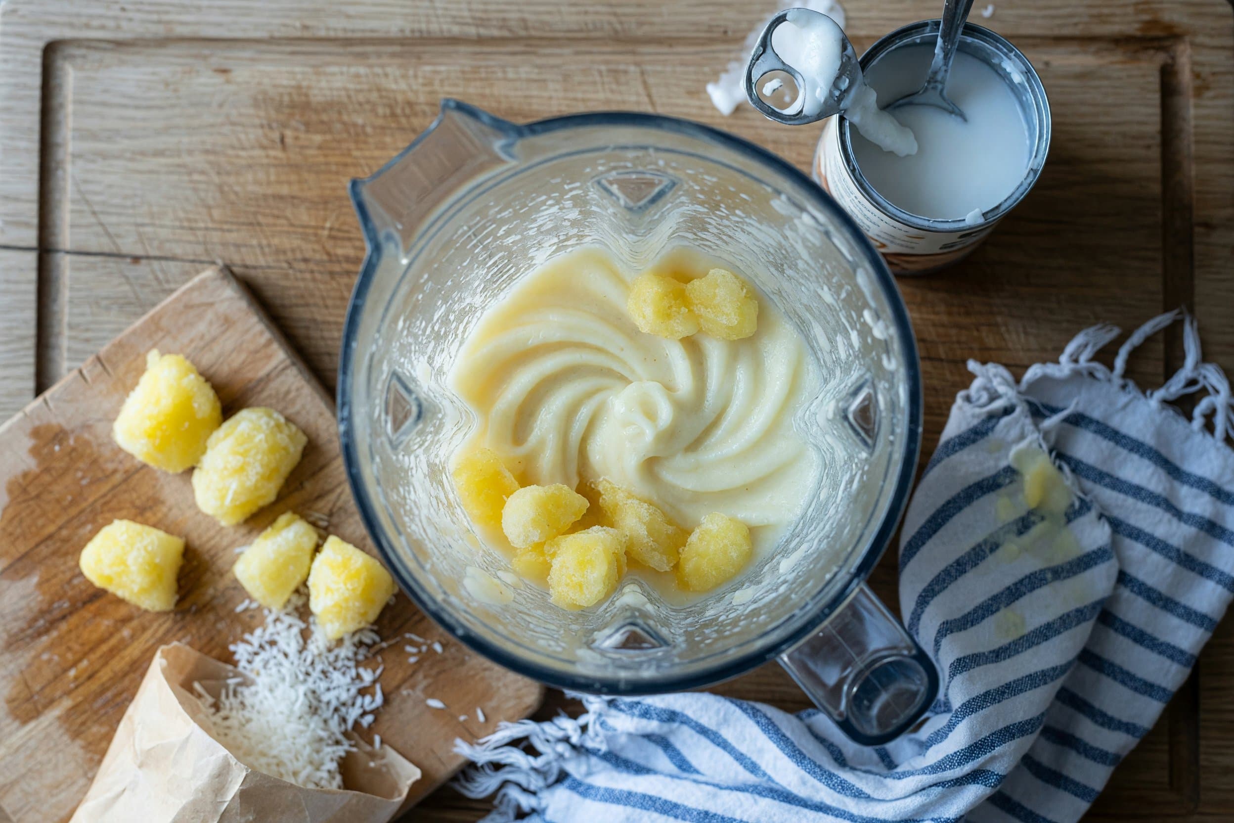 Whisking frozen pineapple and coconut milk while preparing Homemade Disneyland Coconut Dole Whip Recipe