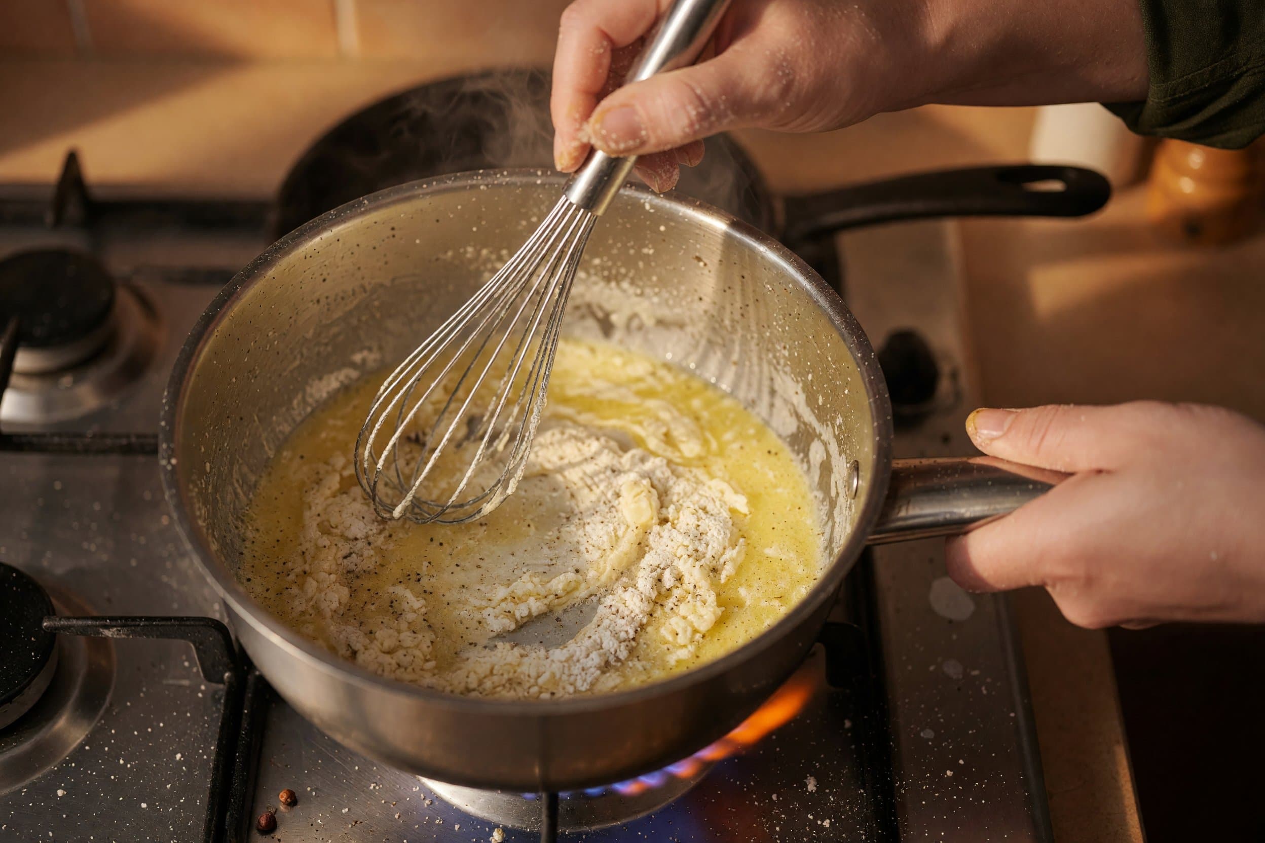 Whisking flour into melted butter while preparing One Pot Cacio e Pepe Mac and Cheese