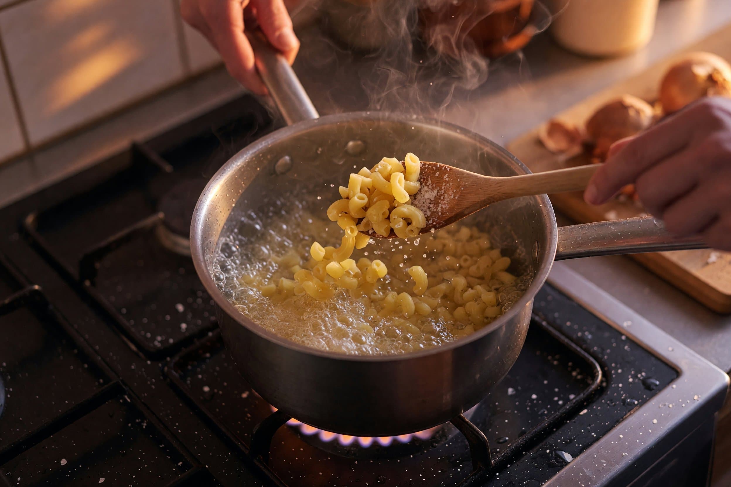 Stirring elbow macaroni and water while preparing Creamy Evaporated Milk Mac n' Cheese Recipe