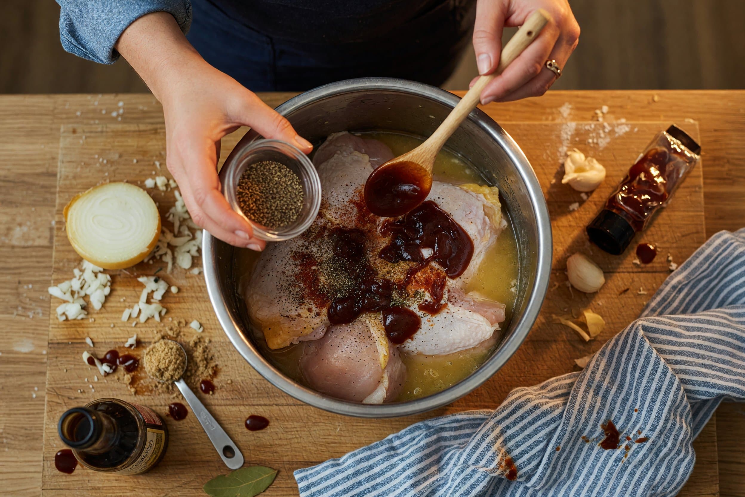Stirring chicken stock, chicken, spices, BBQ sauce, onion, brown sugar, and while preparing Instant Pot BBQ Chicken