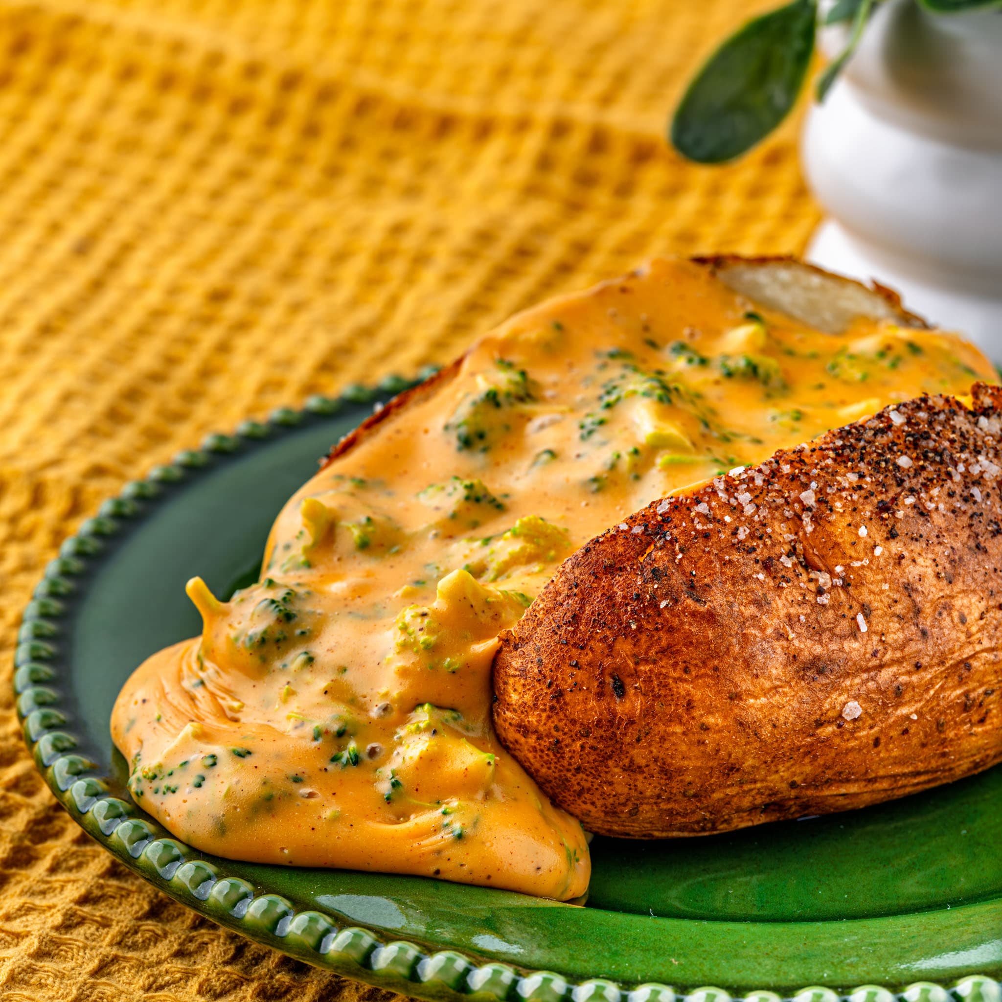 Cheesy baked potatoes loaded with broccoli cheddar sauce, finished with fresh chives.