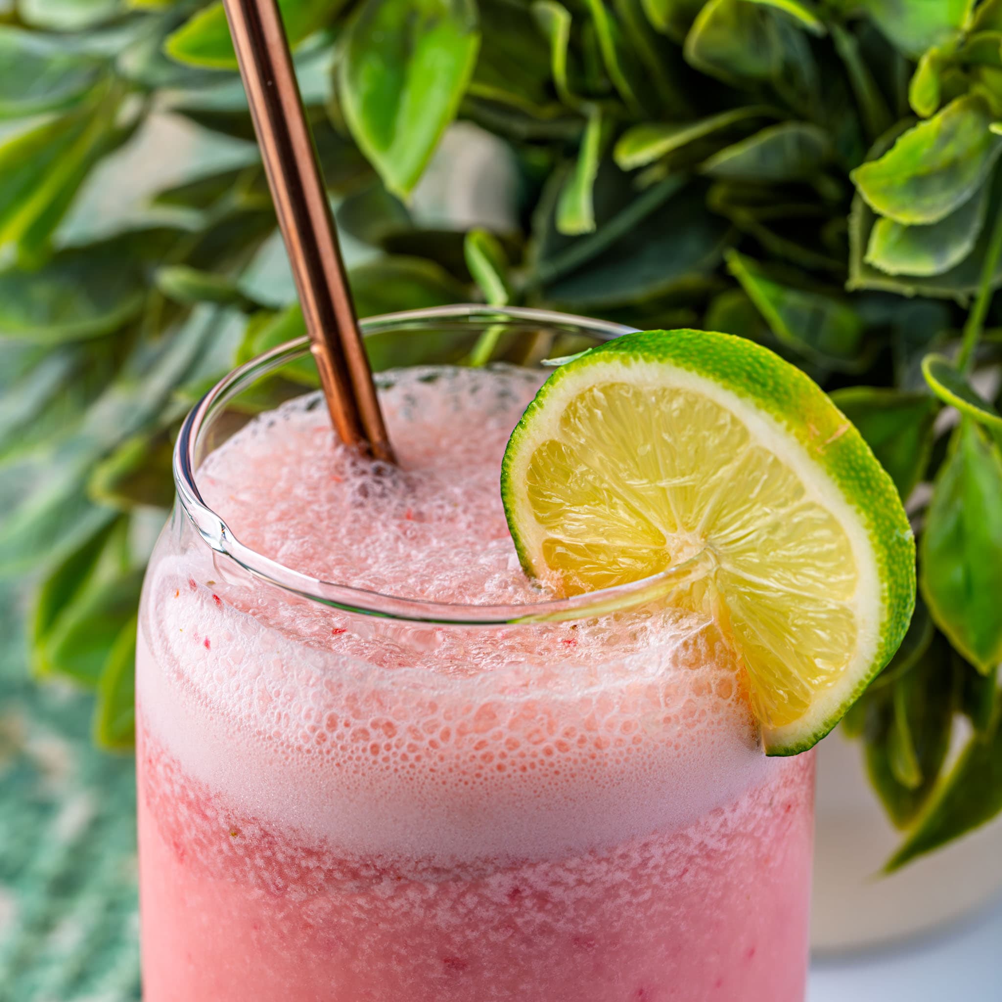 A frosty glass of pink Brazilian strawberry limeade, ready to sip.