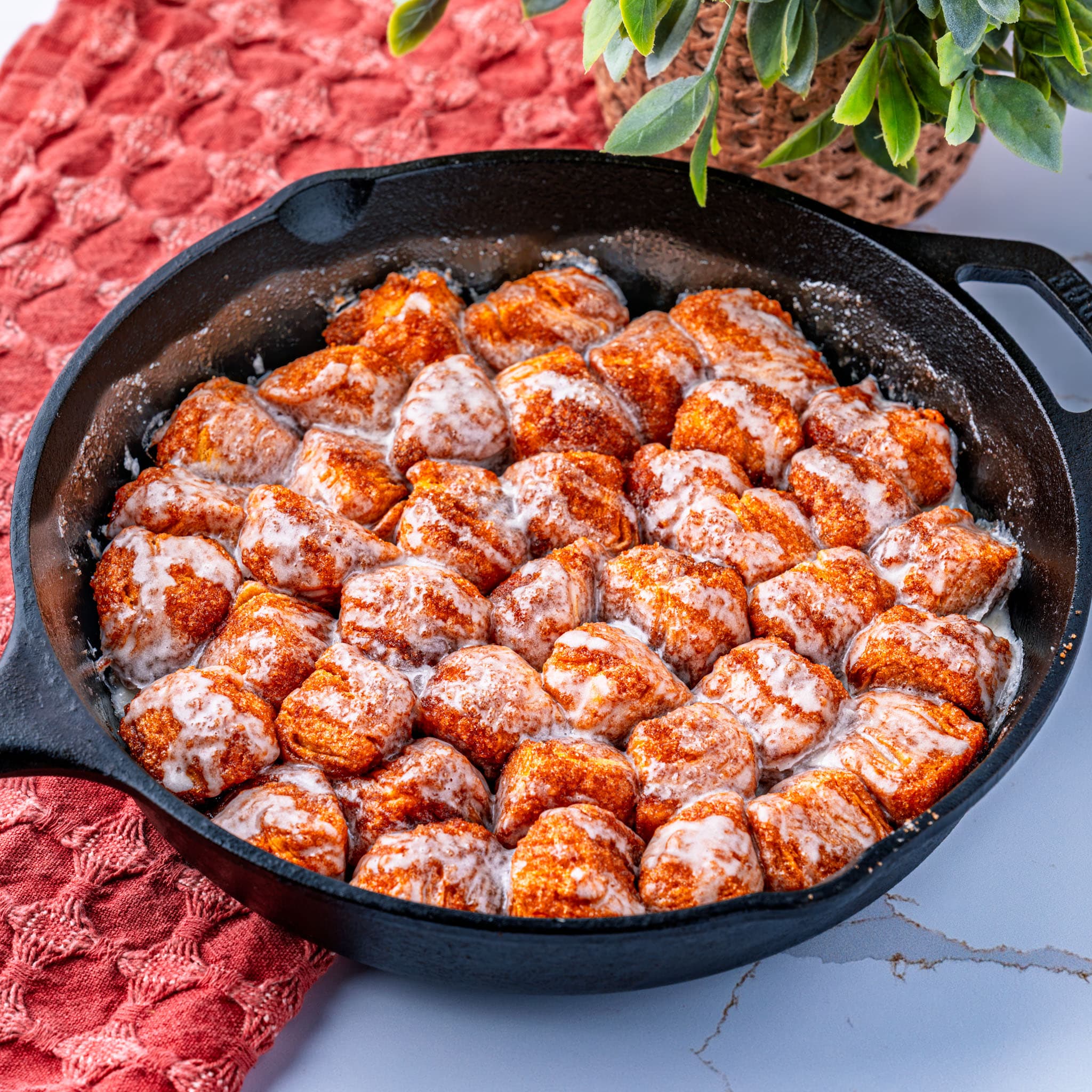 A golden, gooey skillet of monkey bread fresh out of the oven, glaze still dripping down the sides.