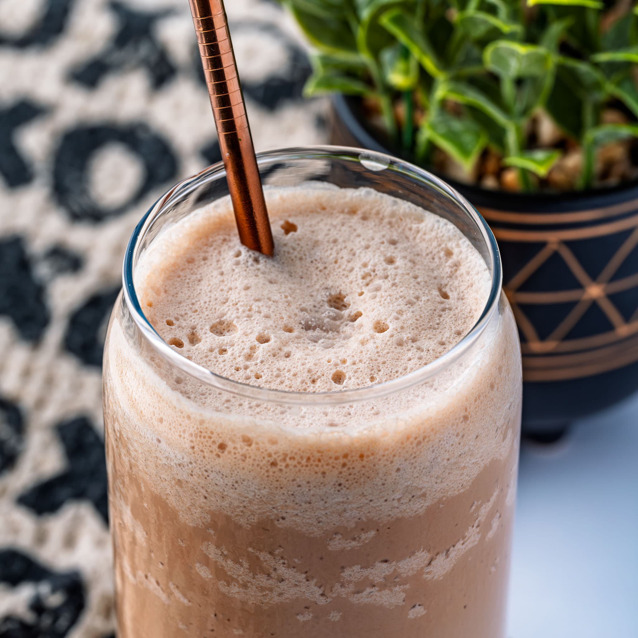 A tall glass of frozen coffee, whipped cream and chocolate drizzle on top.