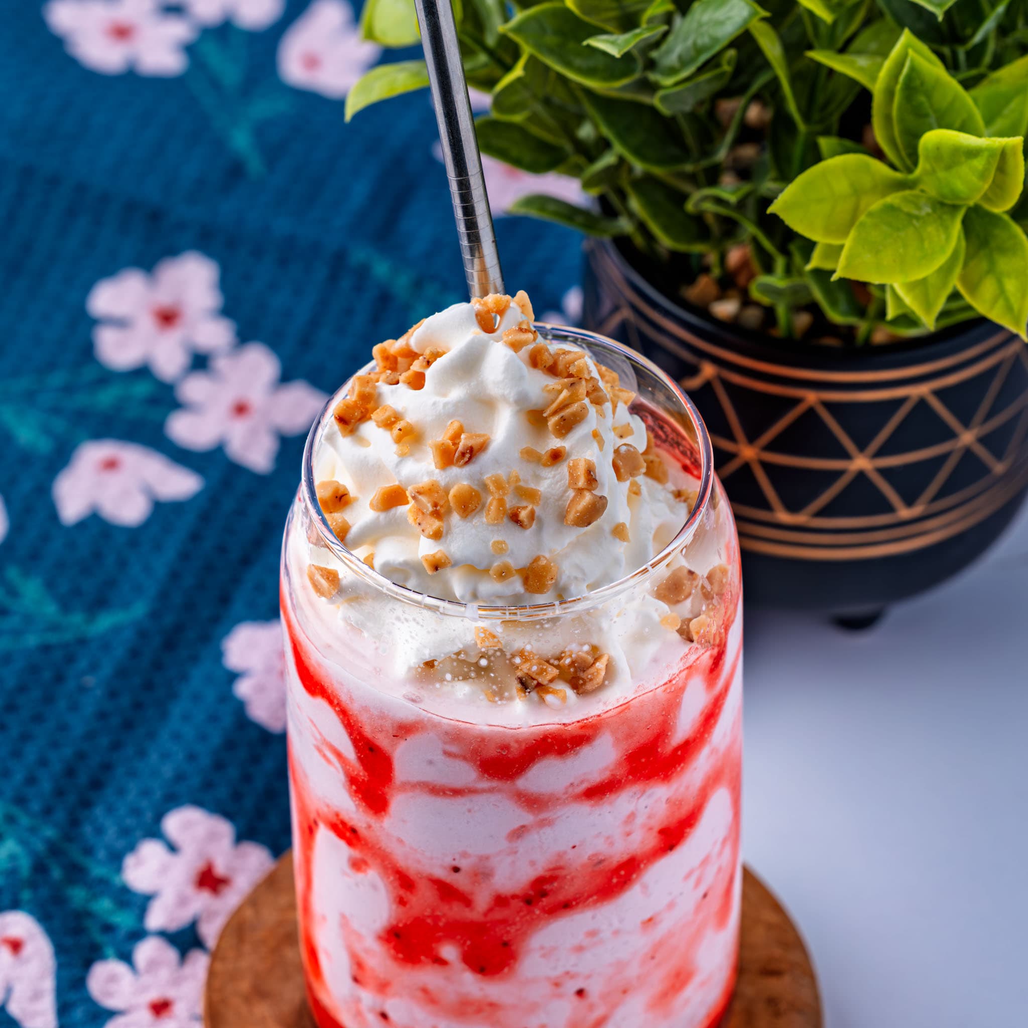 A frosty pink frappuccino swirled with whipped cream and toffee bits, ready to sip.