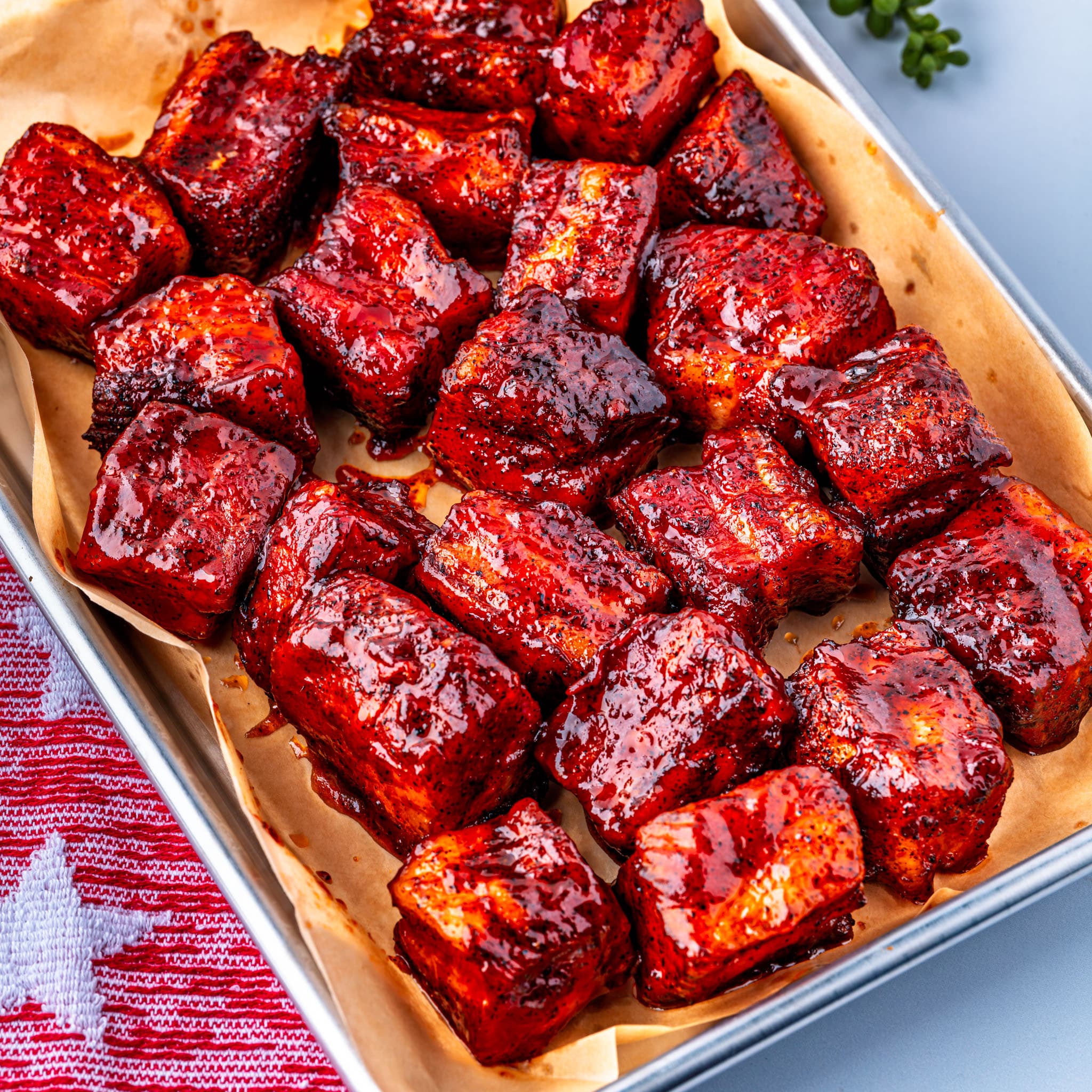 Lacquered pork belly burnt ends fresh off the smoker — sticky, dark, and ready for toothpicks.