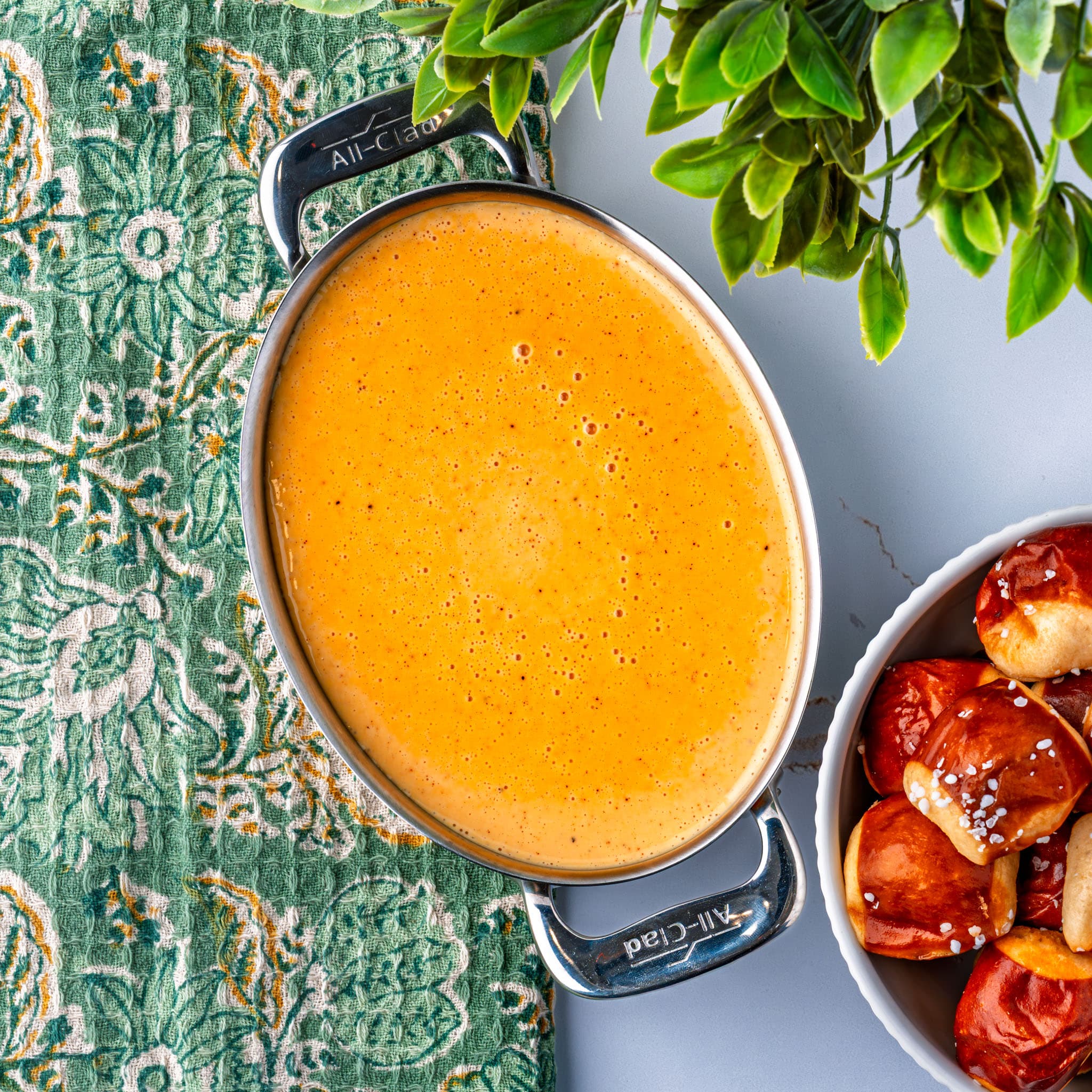 A pot of glossy, spicy nacho cheese ready for dipping.
