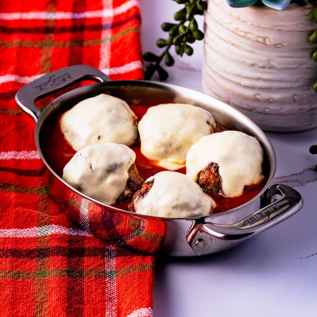 Golden baked meatballs fresh from the oven, served with red sauce and fresh mozzarella.