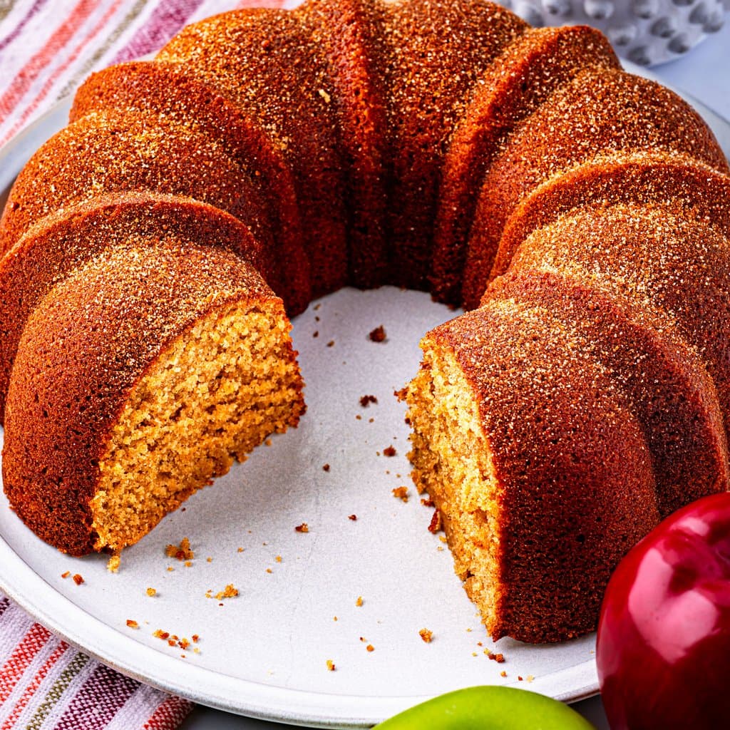 Apple Cider Donut Cake fresh from the bundt pan, dusted with cinnamon sugar and ready to slice.