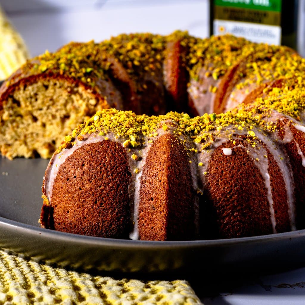Pistachio Olive Oil Bundt Cake finished with vanilla glaze and crushed pistachios.