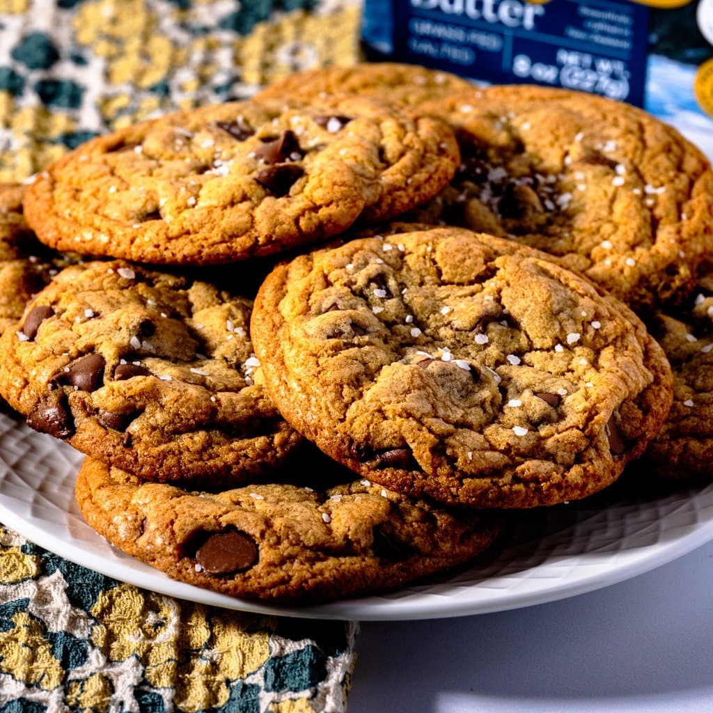 Golden-edged brown butter chocolate chip cookies fresh from the oven, finished with flaky sea salt.