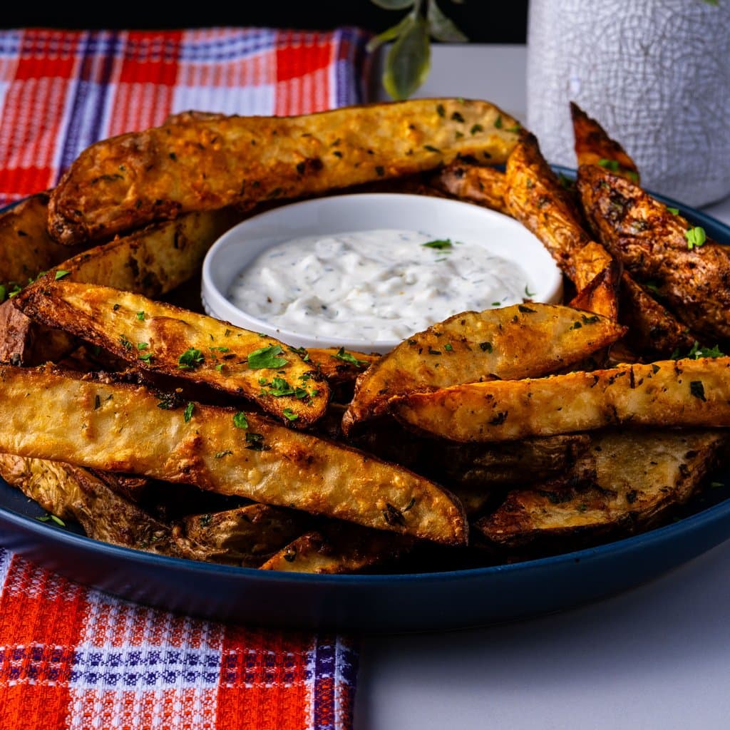 Golden, crispy potato wedges fresh from the air fryer, dusted with parmesan and parsley.