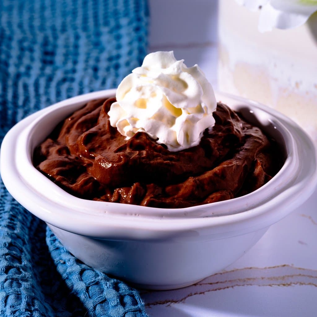 Homemade chocolate pudding topped with a generous dollop of whipped cream — rich, silky, and ready to steal the show.
