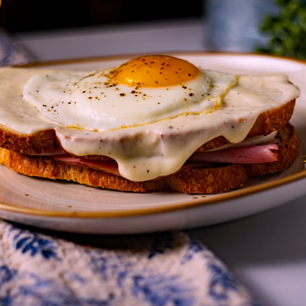Croque Madame with a runny fried egg, bubbling Gruyère béchamel, and golden toasted bread.