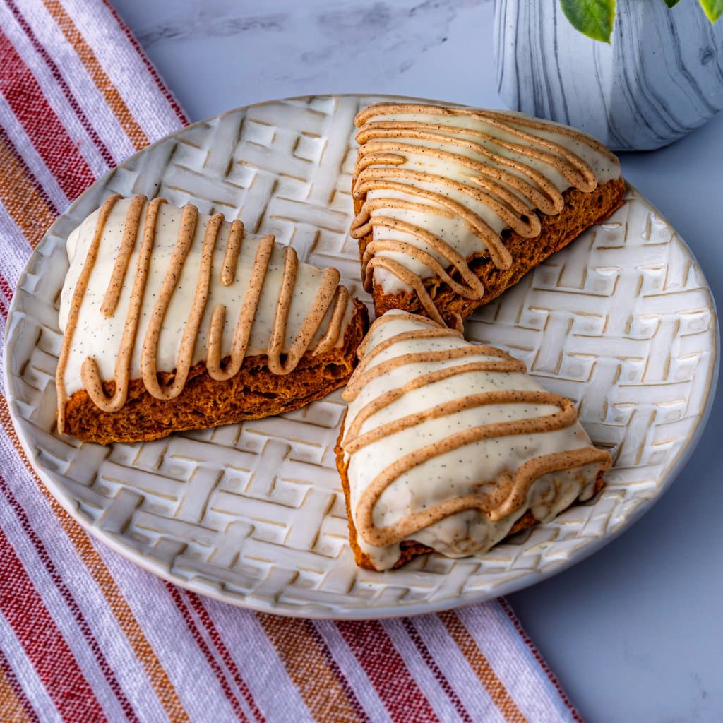 Super soft pumpkin scones drizzled with vanilla icing — golden, spiced, and ready for fall.